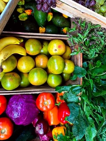 Cajas de madera con frutas, verduras y hoja verde seleccionadas por Fruva